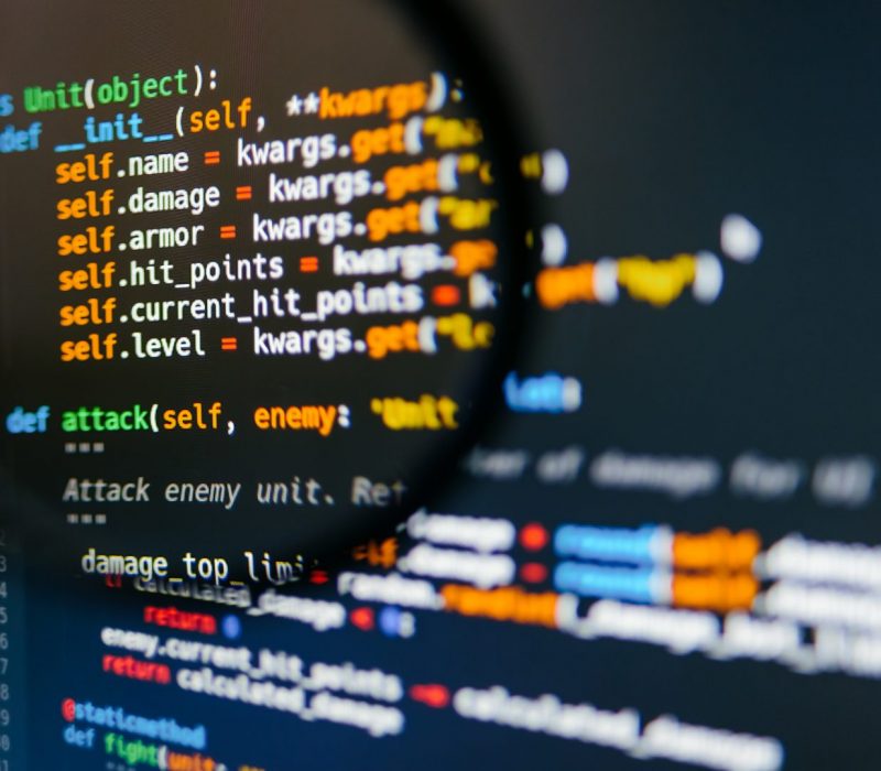 program-code-on-computer-display-in-magnifying-gla-2024-12-05-07-12-20-utc